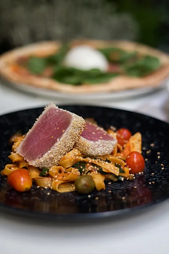Grillowany stek z tuńczyka w sezamie obok pizzy z burratą